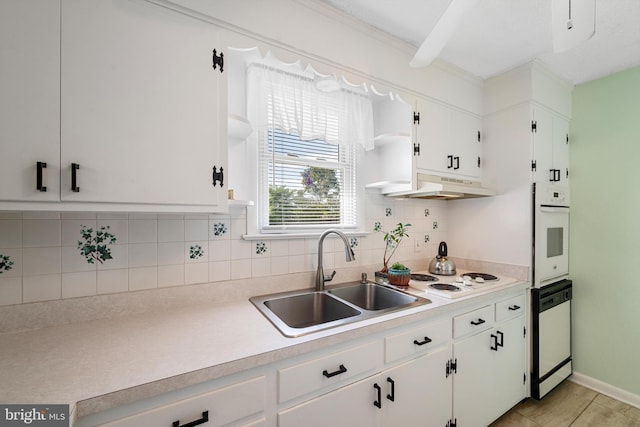 kitchen featuring sink, light tile patterned floors, white appliances, decorative backsplash, and white cabinets