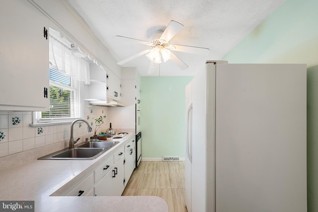 kitchen featuring tasteful backsplash, sink, white cabinets, ceiling fan, and white appliances