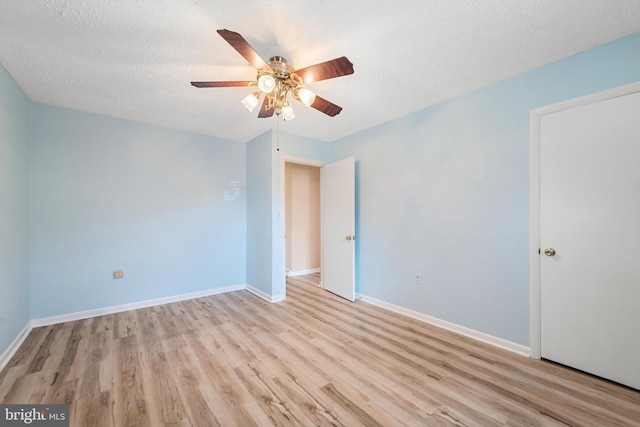 unfurnished room featuring ceiling fan, a textured ceiling, and light wood-type flooring