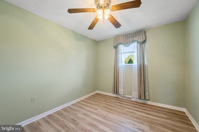 unfurnished room with ceiling fan, light hardwood / wood-style flooring, and a textured ceiling