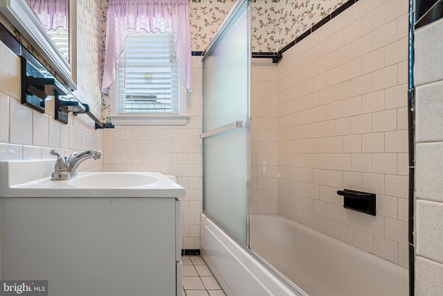 bathroom with tile walls, sink, tile patterned flooring, and combined bath / shower with glass door