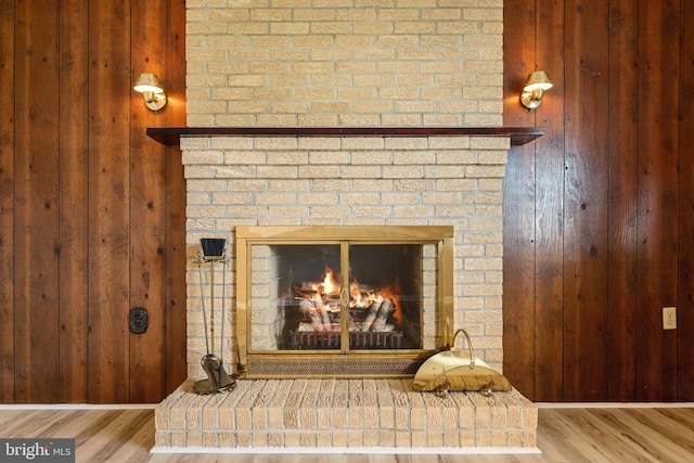 interior details featuring wooden walls, wood-type flooring, and a fireplace