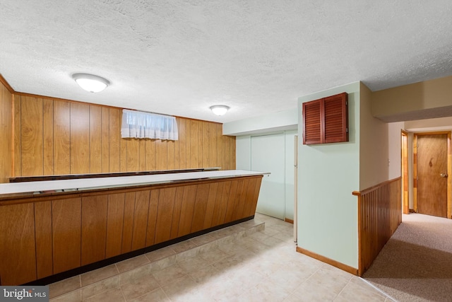 bar with a textured ceiling and wooden walls