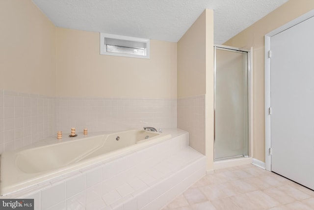 bathroom with shower with separate bathtub and a textured ceiling