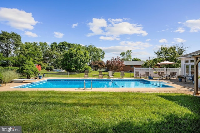 view of swimming pool featuring a lawn and a diving board