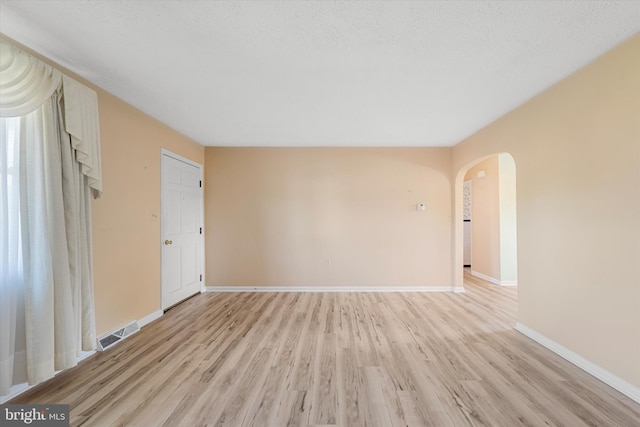 empty room featuring light hardwood / wood-style flooring and a textured ceiling