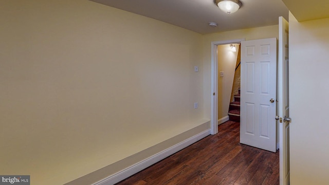 corridor with dark hardwood / wood-style flooring