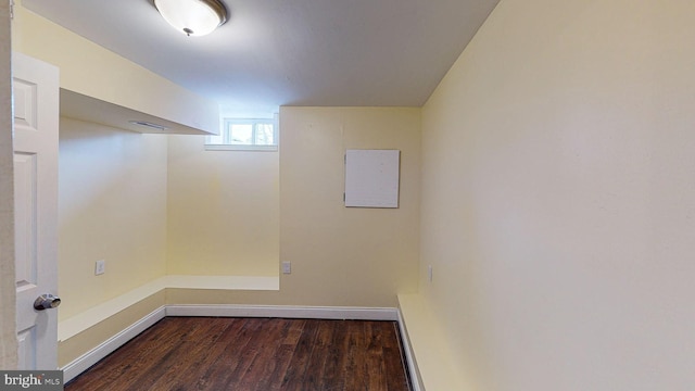 basement featuring electric panel and dark hardwood / wood-style floors