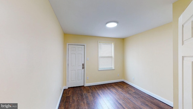 empty room with dark hardwood / wood-style flooring