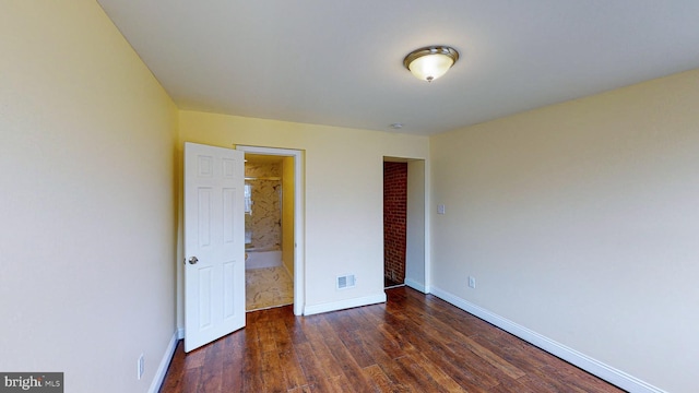 unfurnished bedroom featuring a closet and dark wood-type flooring