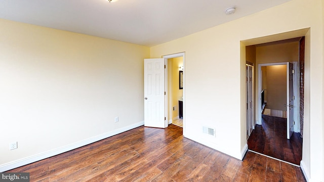 unfurnished bedroom featuring dark wood-type flooring and a closet