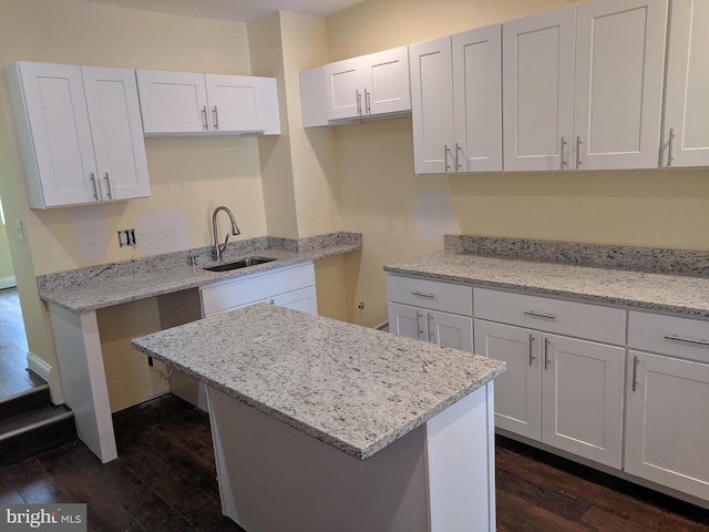 kitchen featuring sink, white cabinetry, dark wood-type flooring, and light stone countertops