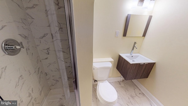 bathroom with tiled shower, vanity, and toilet