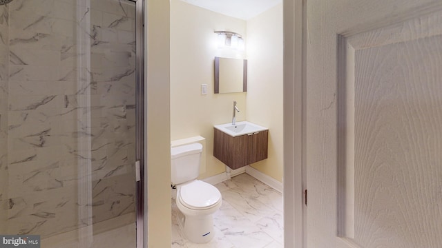 bathroom with toilet, tiled shower, and vanity