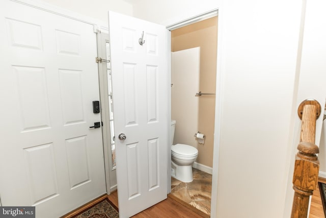 bathroom with hardwood / wood-style flooring and toilet