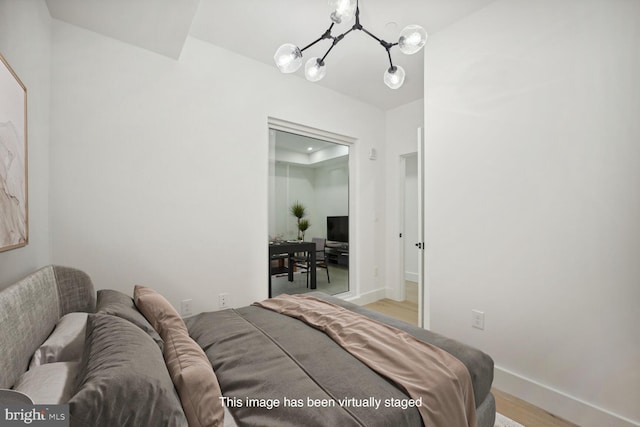 bedroom featuring a chandelier and light hardwood / wood-style flooring