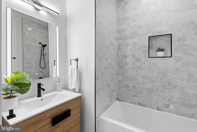 bathroom featuring vanity and tiled shower / bath