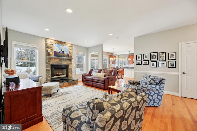 living area with light wood-type flooring, a fireplace, baseboards, and recessed lighting