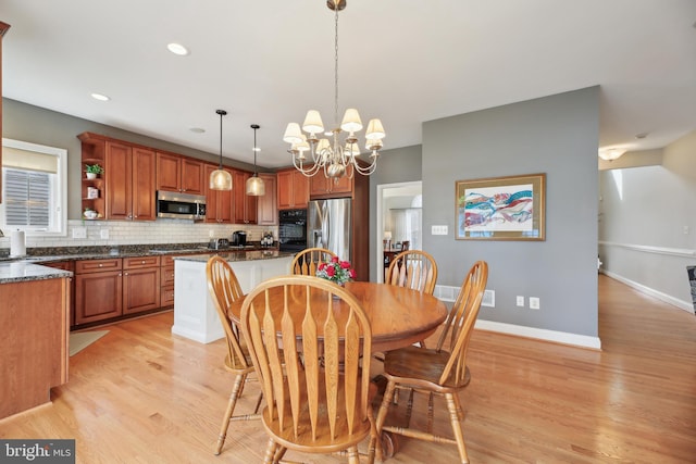 dining room featuring light wood-style floors, baseboards, a notable chandelier, and recessed lighting