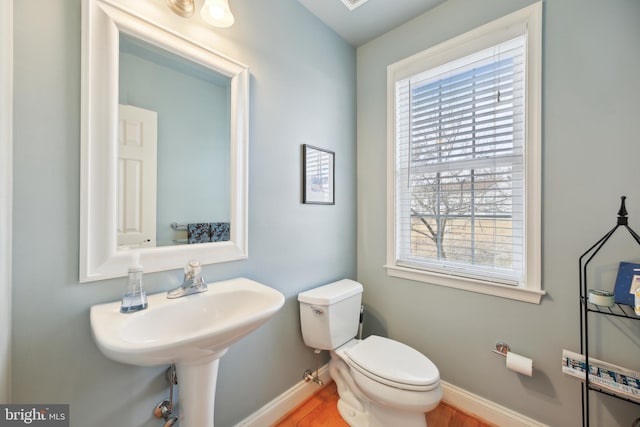 bathroom featuring wood finished floors, toilet, and baseboards