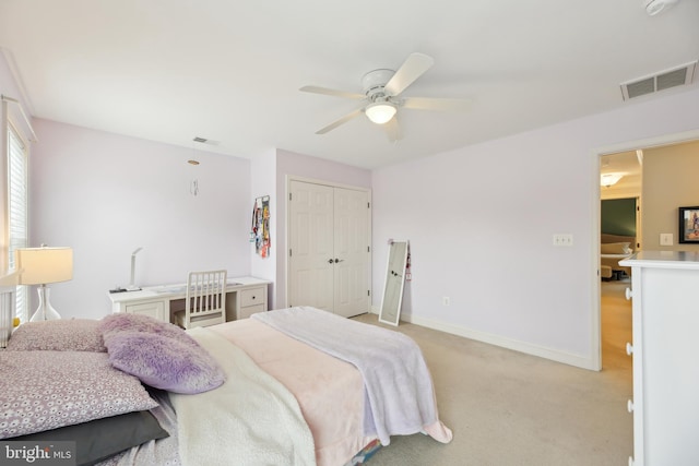 bedroom featuring a closet, light colored carpet, visible vents, and baseboards