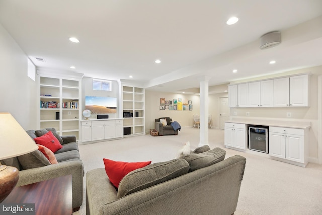 living area featuring light carpet, wine cooler, a bar, and recessed lighting