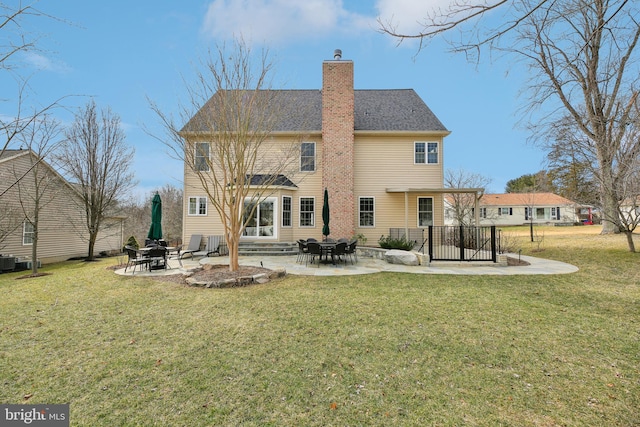 back of house with entry steps, a lawn, a chimney, central air condition unit, and a patio area