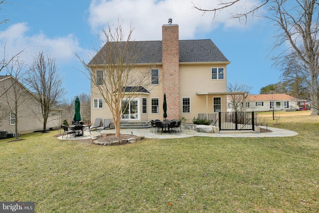 rear view of property with a patio area, a chimney, and a yard