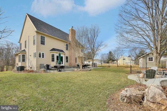 exterior space with central AC, a patio, a yard, and a chimney