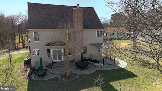 back of property featuring entry steps, a patio, central AC, a yard, and a chimney