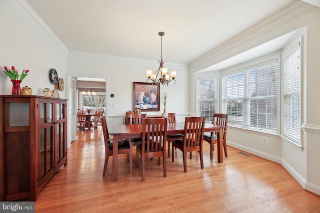 dining room featuring visible vents, ornamental molding, a chandelier, light wood-type flooring, and baseboards