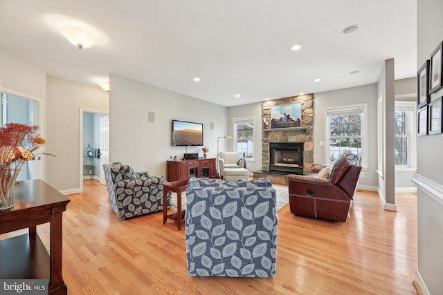 living room with recessed lighting, a fireplace, light wood-style flooring, and baseboards