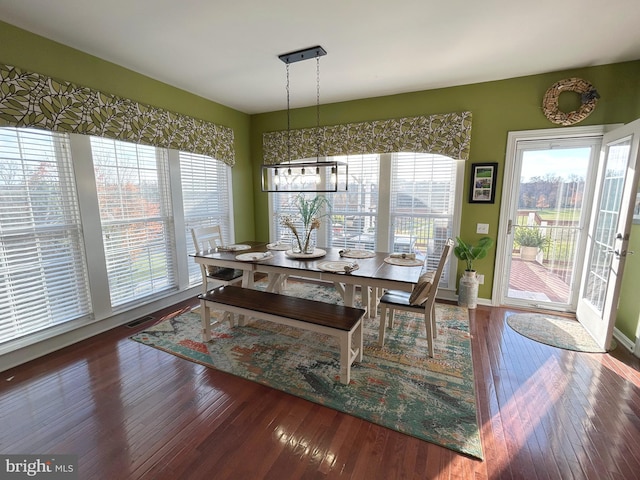 dining area featuring a notable chandelier and dark hardwood / wood-style flooring