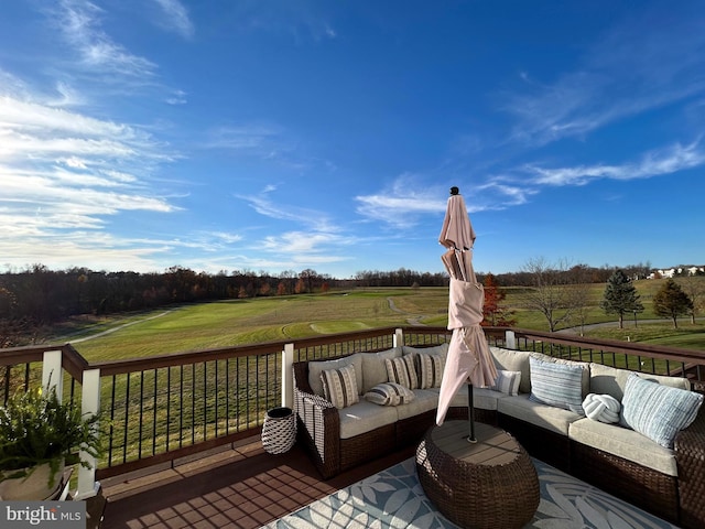 deck with a rural view, a yard, and outdoor lounge area