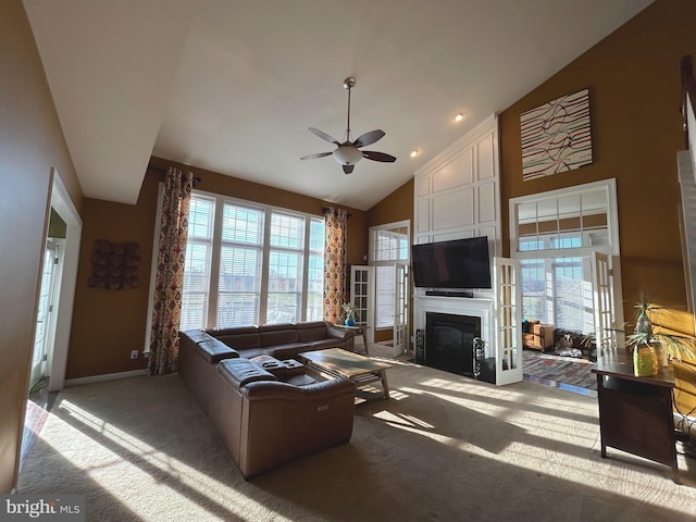 carpeted living room featuring high vaulted ceiling and ceiling fan