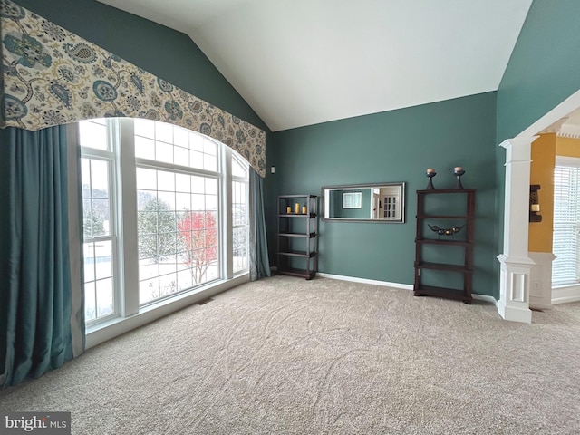 interior space featuring plenty of natural light, lofted ceiling, carpet, and ornate columns