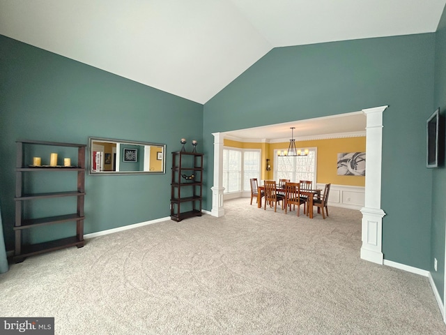 interior space with lofted ceiling, decorative columns, an inviting chandelier, and ornamental molding