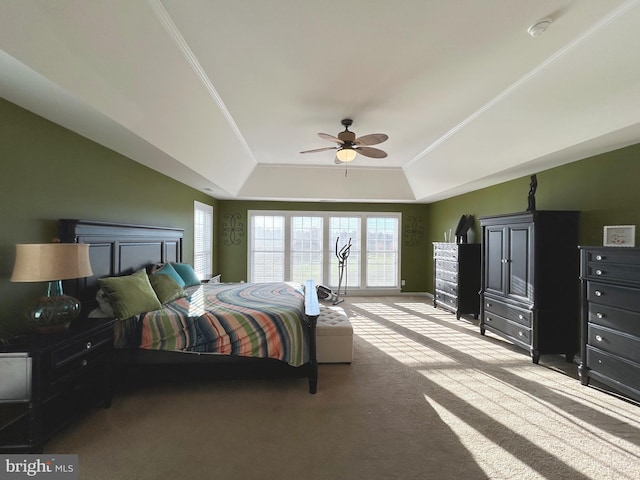 carpeted bedroom with ornamental molding, a raised ceiling, and ceiling fan