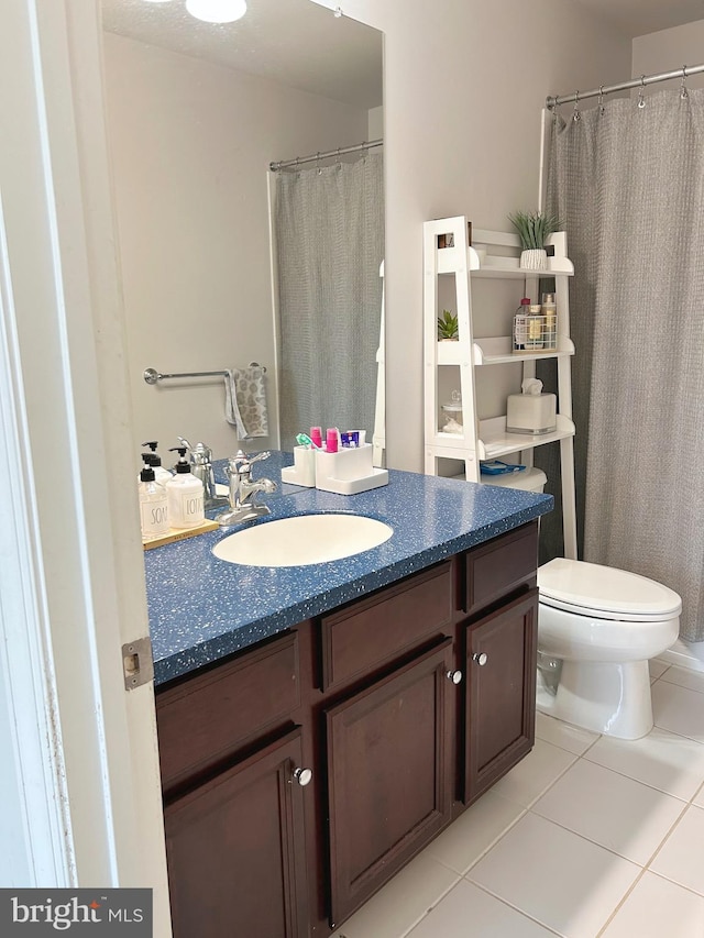 bathroom with vanity, tile patterned flooring, and toilet