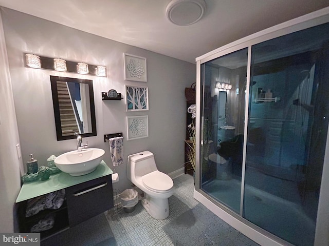 bathroom with toilet, tile patterned flooring, a shower with shower door, and vanity