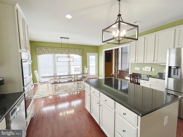 kitchen featuring decorative light fixtures, stainless steel appliances, and white cabinetry