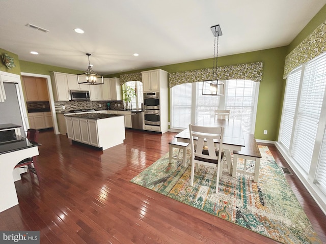 dining room with sink, a healthy amount of sunlight, a notable chandelier, and dark hardwood / wood-style floors