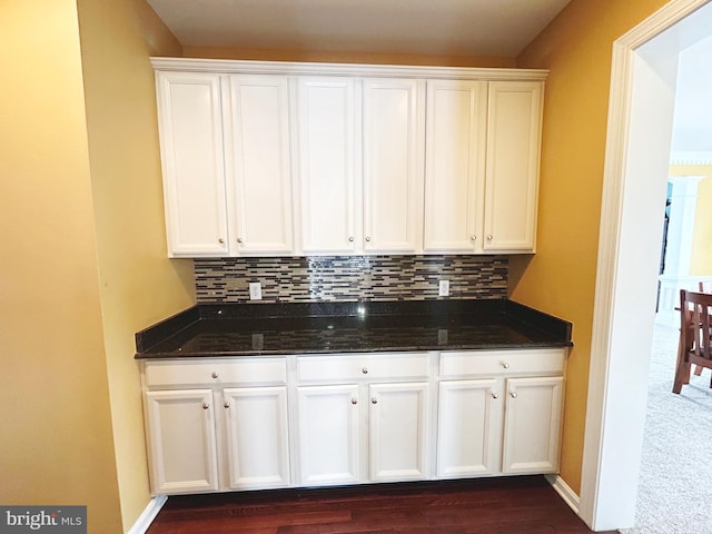 kitchen featuring white cabinets, dark stone countertops, and tasteful backsplash