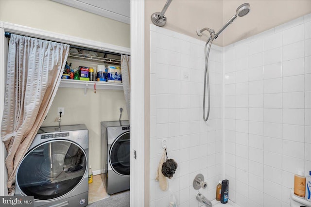 clothes washing area featuring light tile patterned floors and washer and clothes dryer