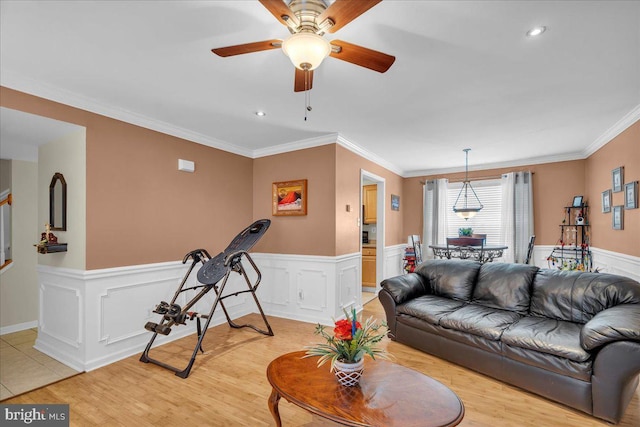 living room featuring ceiling fan, crown molding, and light hardwood / wood-style floors