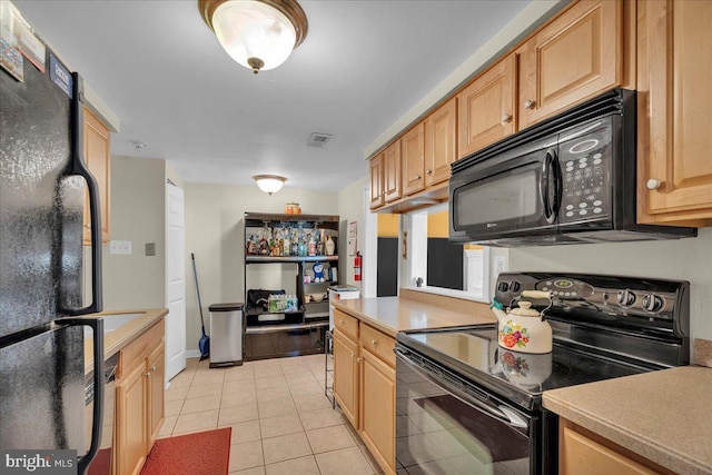 kitchen featuring black appliances, light brown cabinetry, and light tile patterned flooring