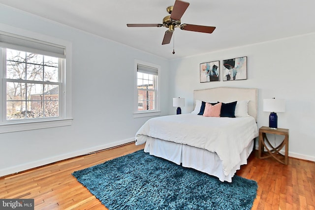 bedroom with hardwood / wood-style flooring, crown molding, and ceiling fan