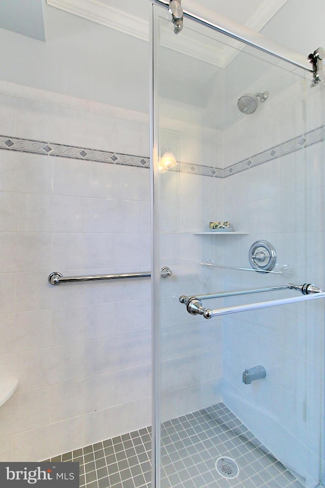 bathroom with ornamental molding and walk in shower