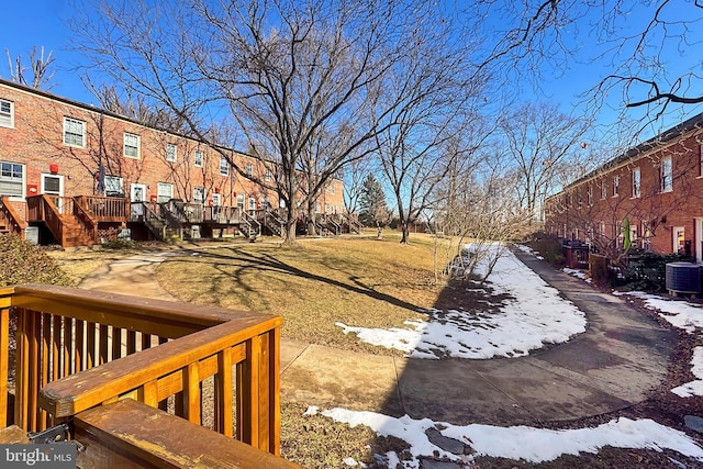 yard layered in snow with a deck and central air condition unit