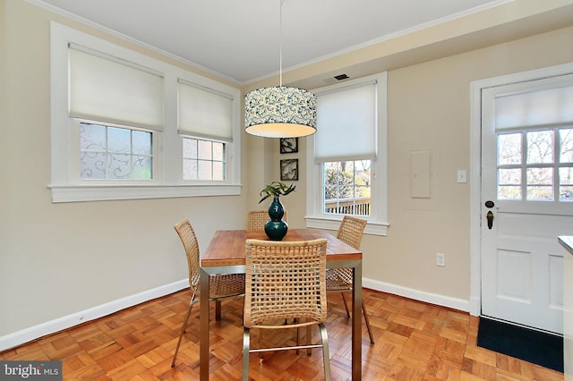 dining space featuring ornamental molding and light parquet flooring